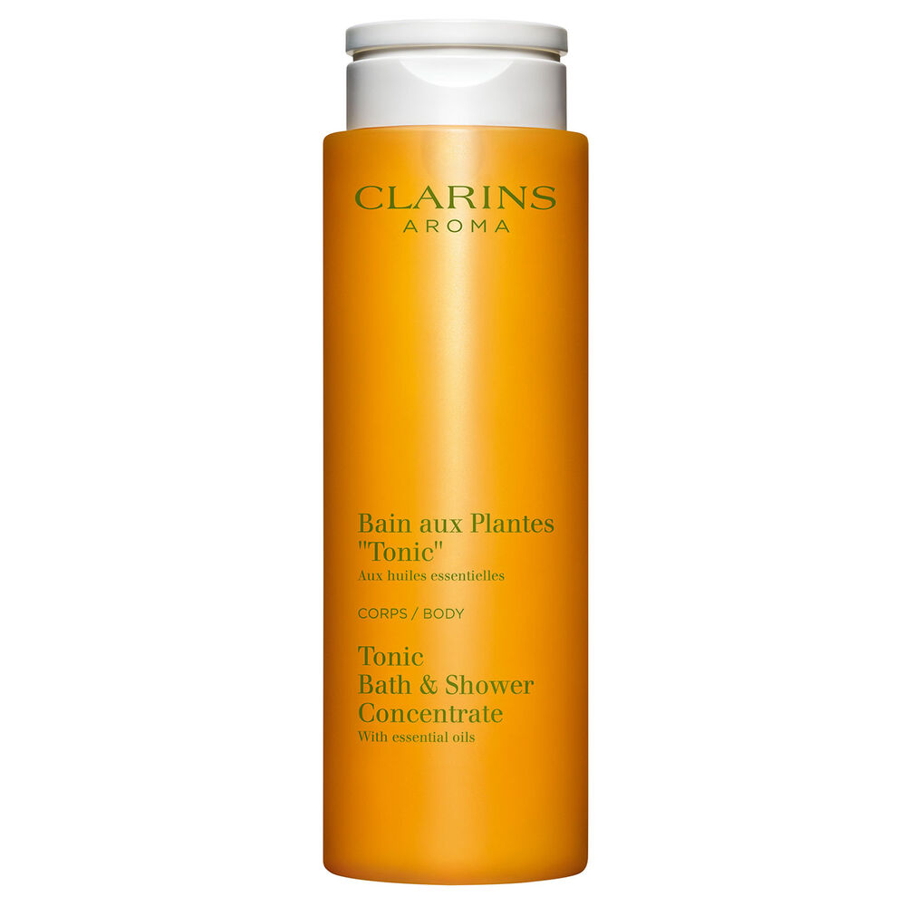 ภาพผลิตภัณฑ์ของ Clarins Tonic Bath และ Shower Concentrate ที่วางอยู่ใกล้กับใบสะระแหน่และโรสแมรี่บนพื้นหลังสีส้ม