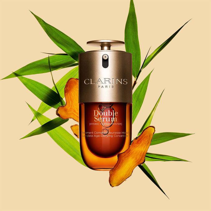 ภาพบรรจุภัณฑ์ของ Clarins Double Serum ที่แสดงอยู่ด้านหน้าส่วนผสม รวมถึง Curcuma บนพื้นหลังสีทอง