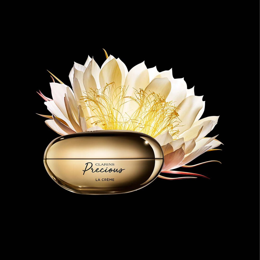 ภาพผลิตภัณฑ์ Clarins Precious Soft Cream ที่ถูกวางอยู่ใกล้กับดอกมูนไลท์บนพื้นหลังสีเข้ม