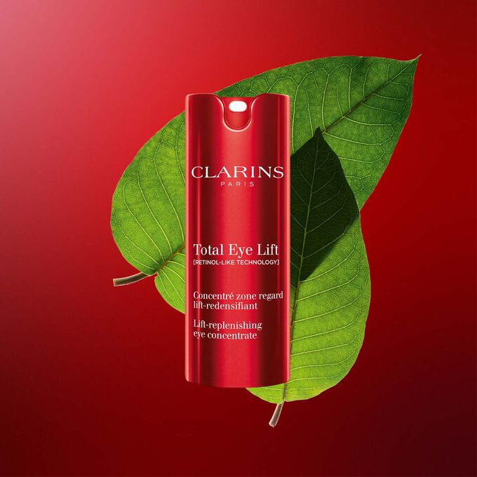 ภาพถ่ายผลิตภัณฑ์คลาแรงส์ Total Eye Lift ครีมบำรุงรอบดวงตาเพื่อการลดเลือนริ้วรอยแห่งวัยที่มีใบ Harungana บนพื้นหลังสีแดงเข้ม