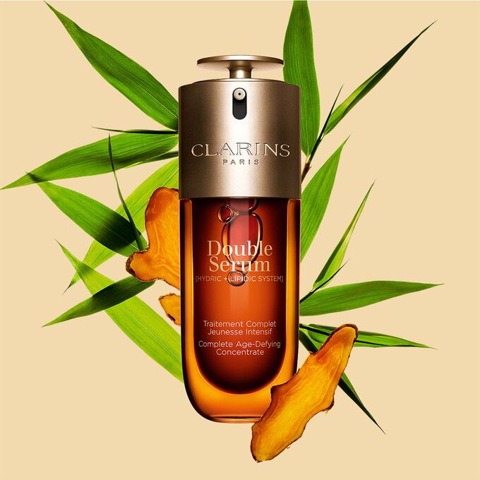 ภาพบรรจุภัณฑ์ของ Clarins Double Serum ที่แสดงอยู่ด้านหน้าส่วนผสม รวมถึง Curcuma บนพื้นหลังสีทอง