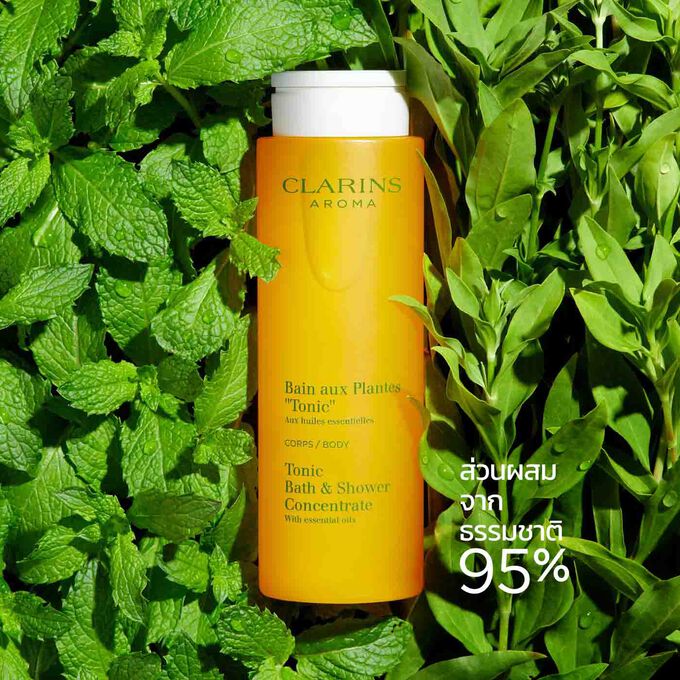 ขวดของ Clarins Tonic Bath และ Shower Concentrate ถูกวางอยู่ท่ามกลางใบมิ้นต์และโรสแมรี่ เพื่อเน้นถึงส่วนผสมจากธรรมชาติ