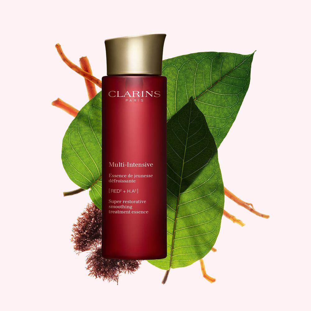 ภาพผลิตภัณฑ์ของ Clarins Super Restorative Treatment Essence ที่ถูกวางใกล้กับสาหร่ายแดงจาเนีย ใบฮารุงกานา และรากโสม บนพื้นหลังสีชมพู