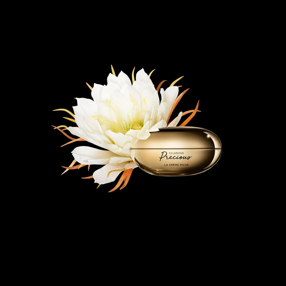 ภาพผลิตภัณฑ์ Clarins Precious Rich Cream ที่วางใกล้กับดอกมูนไลท์บนพื้นหลังสีเข้ม