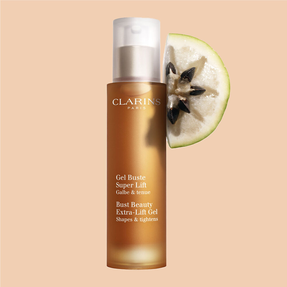 ภาพผลิตภัณฑ์ของขวด Clarins Bust Beauty Extra-lift Gel ที่วางอยู่ใกล้กับผลหว้าบนพื้นหลังสีพีช