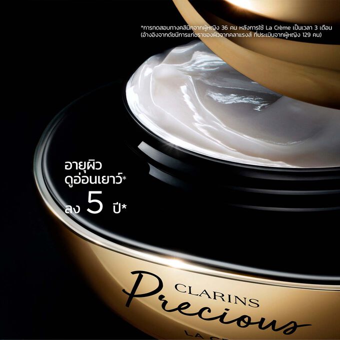 ภาพผลิตภัณฑ์ Clarins Precious Soft Cream บนพื้นหลังสีเข้มพร้อมข้อความที่เน้นถึงประสิทธิภาพในการช่วยให้ผิวดูอ่อนเยาว์ลง 5 ปี